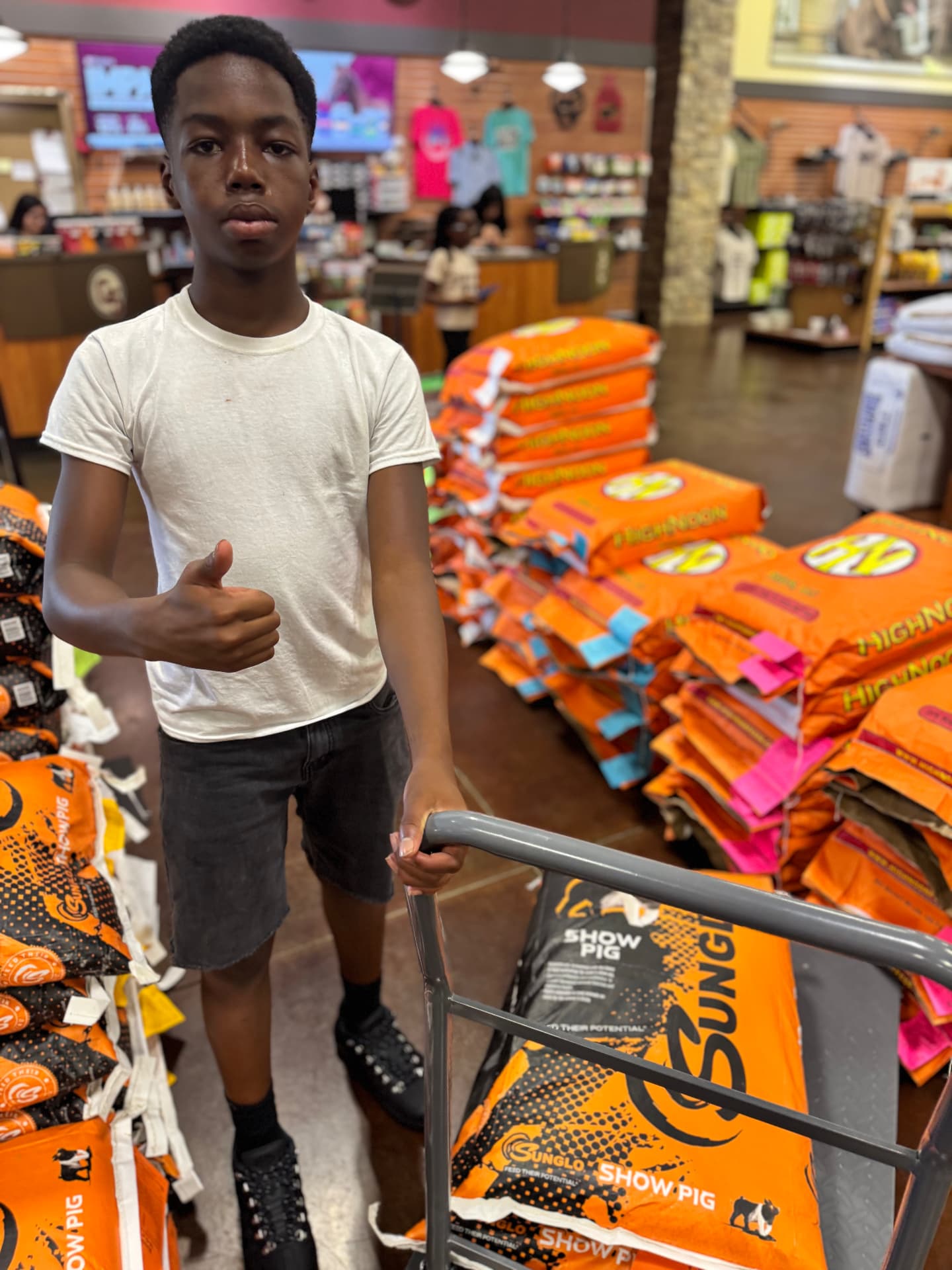 Ethan purchasing show-pig feed with a cart at an agricultural supply store