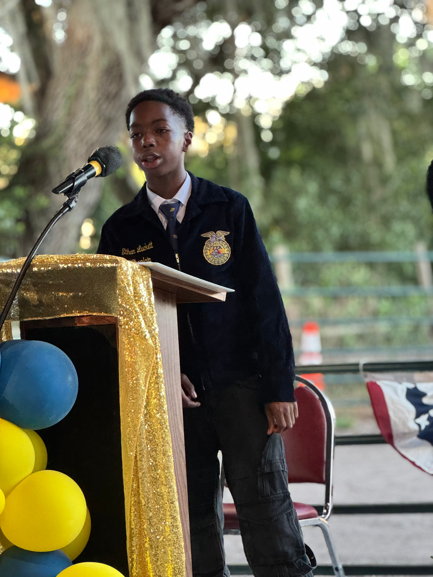 Ethan speaking at a podium in his FFA jacket
